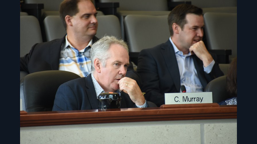File photograph of Chris Murray seated behind a C. Murray nameplate at a Hamilton council meeting on August 18, 2017.